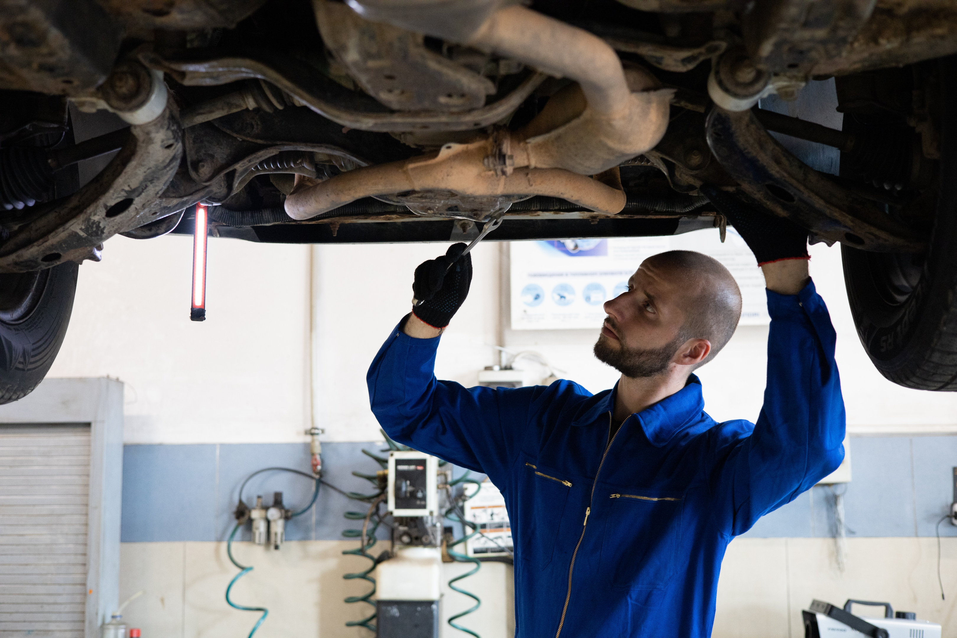 technician examining the underside of the exhaust system