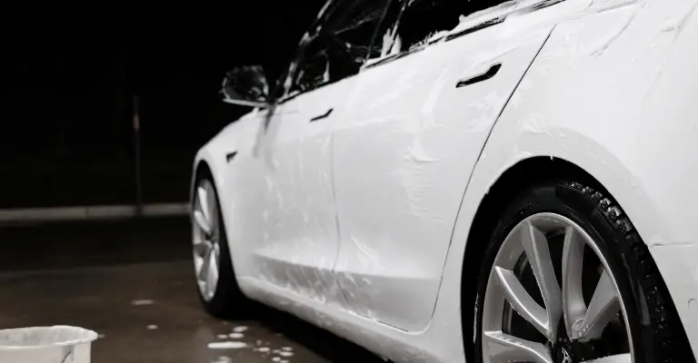 white tesla getting washed in a car detailing bay