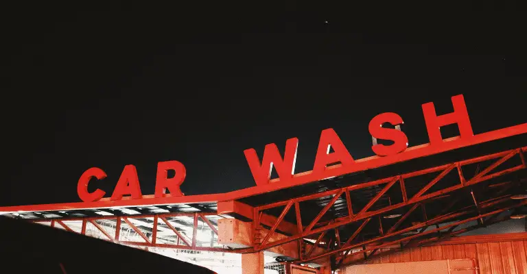 red car wash sign on top of a drive through car wash