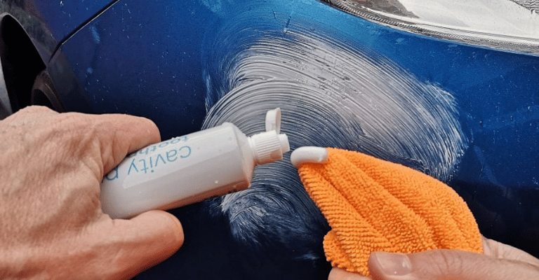 using toothpaste on a car to demonstrate a common method of restoring black plastic trim