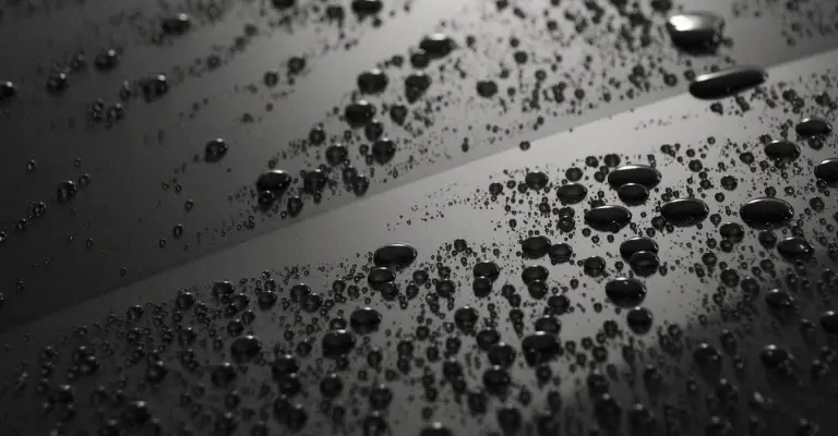 water beading on the surface of a car to show how ceramic coating can prevent water spots