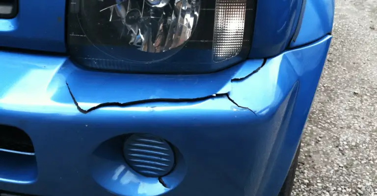 a cracked plastic bumper on a blue nissan truck